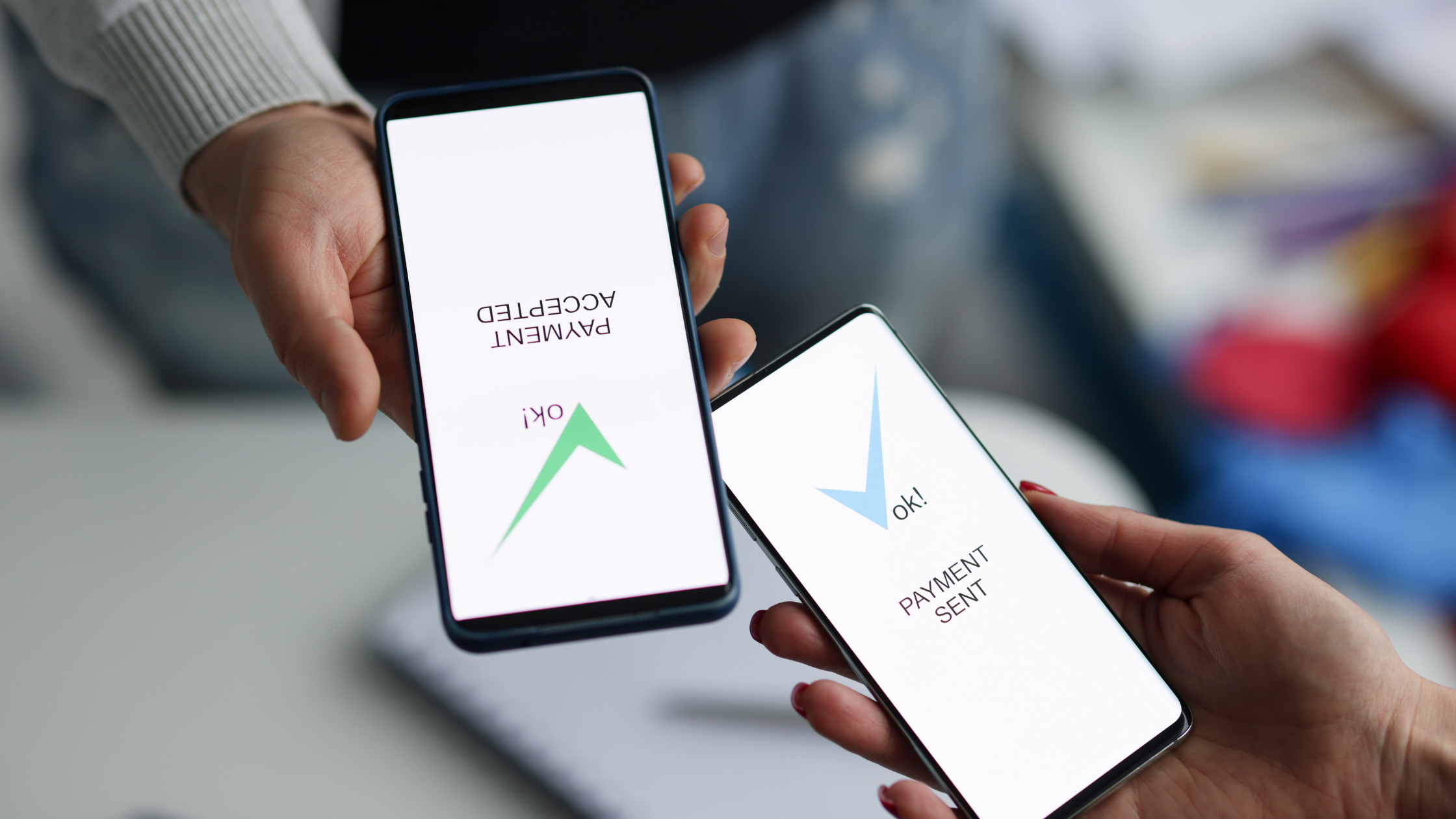  Hands holding phones show payment accepted and sent, illustrating how international payments work.